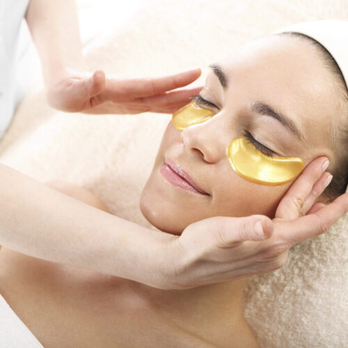 Woman having a gold mask treatment at the spa